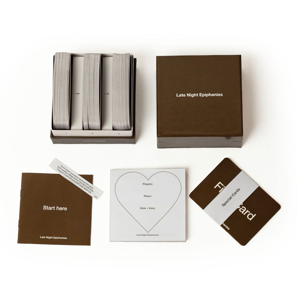 Flat lay of the Late Night Epiphanies card game including box, cards, booklet, notepad, and special cards for meaningful conversations