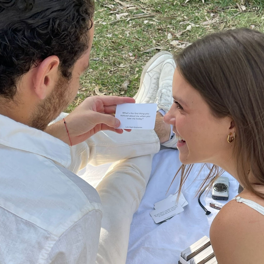 A couple playing the Late Night Epiphanies Card Game, connecting in a picnic date and falling in love.