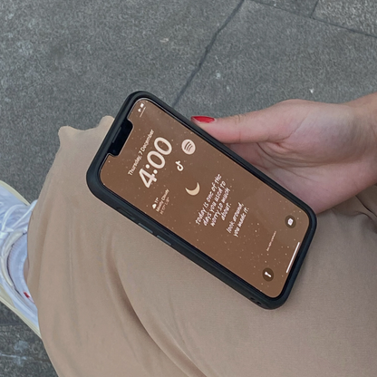Image of someone holding a phone with a brown LNE wallpaper that says "today is one of the days you used to worry so much about. look around, you made it."